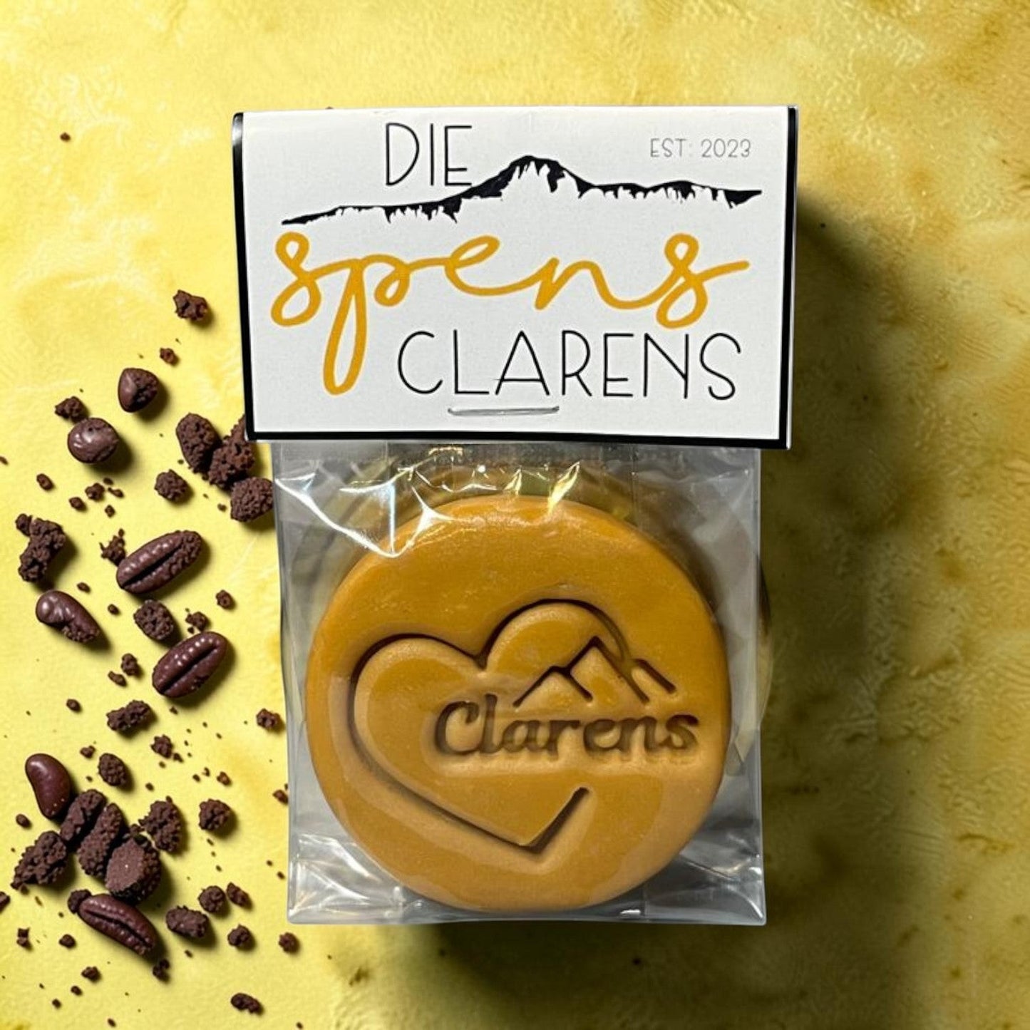 Die Spens Clarens caramel fudge with heart and mountain design, packaged with chocolate pieces.