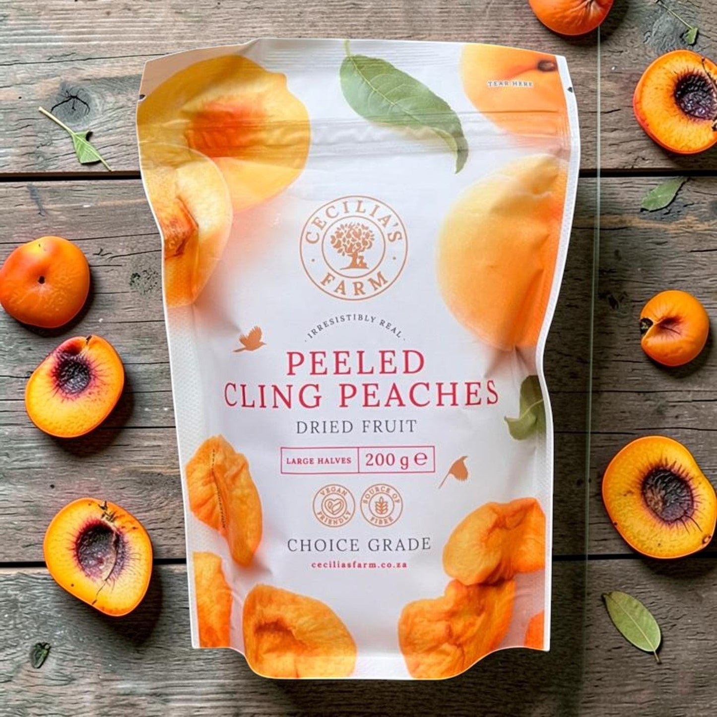 Die Spens Clarens bag of dried cling peach halves, featuring vibrant orange fruit and green leaves. Perfect for snacking.