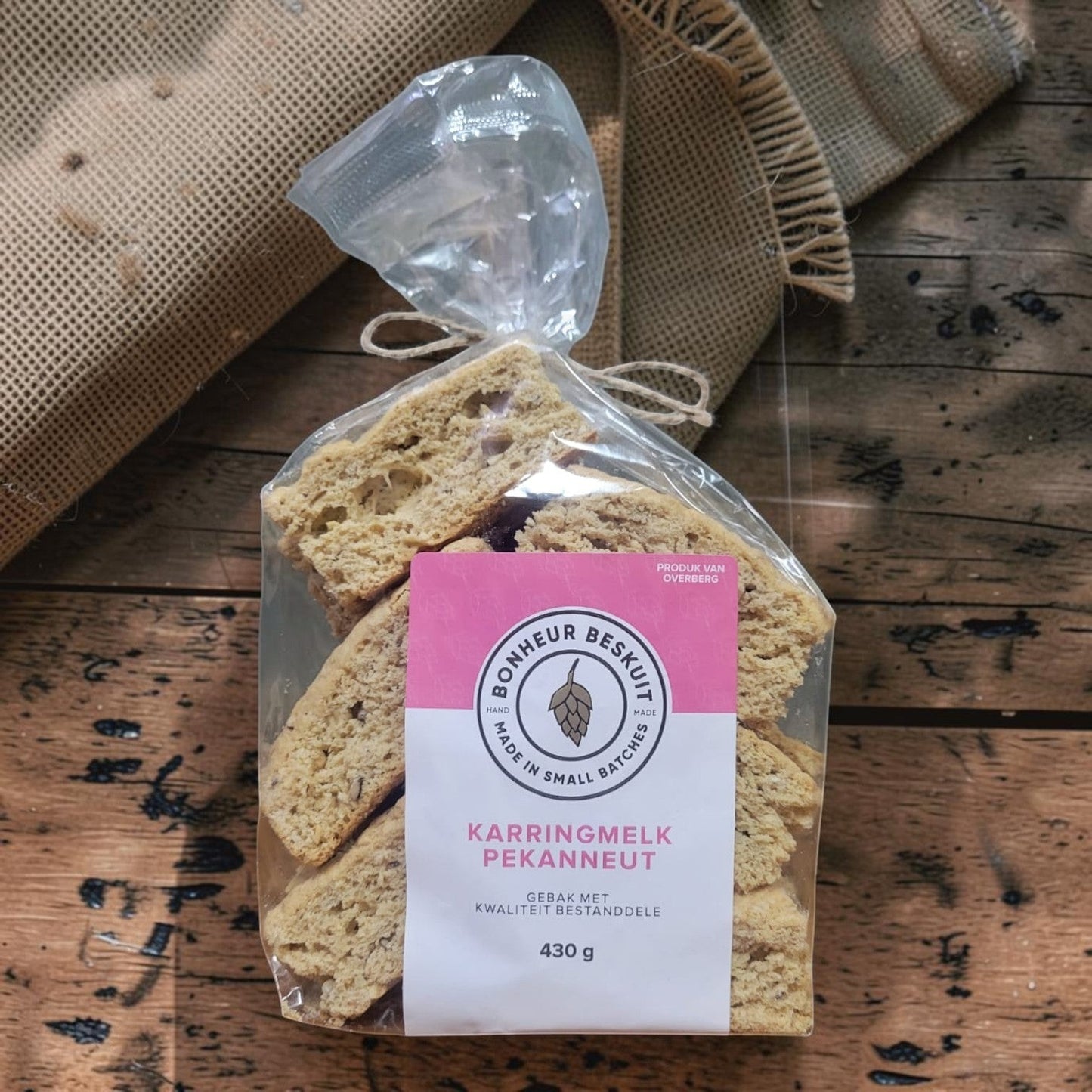 Die Spens Clarens Buttermilk Pecan biscuits in a clear plastic bag with a pink label, showing golden-brown, crunchy texture with visible pecan pieces.