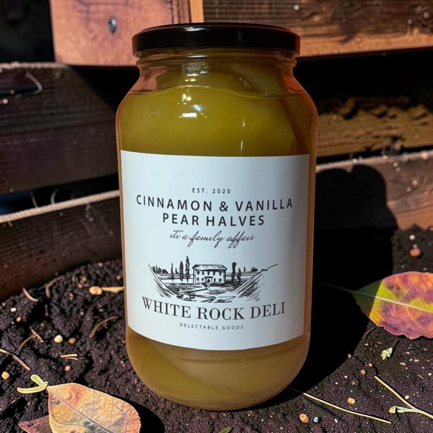 Die Spens Clarens White Rock Deli Cinnamon & Vanilla Pear Halves in syrup, presented in a glass jar.