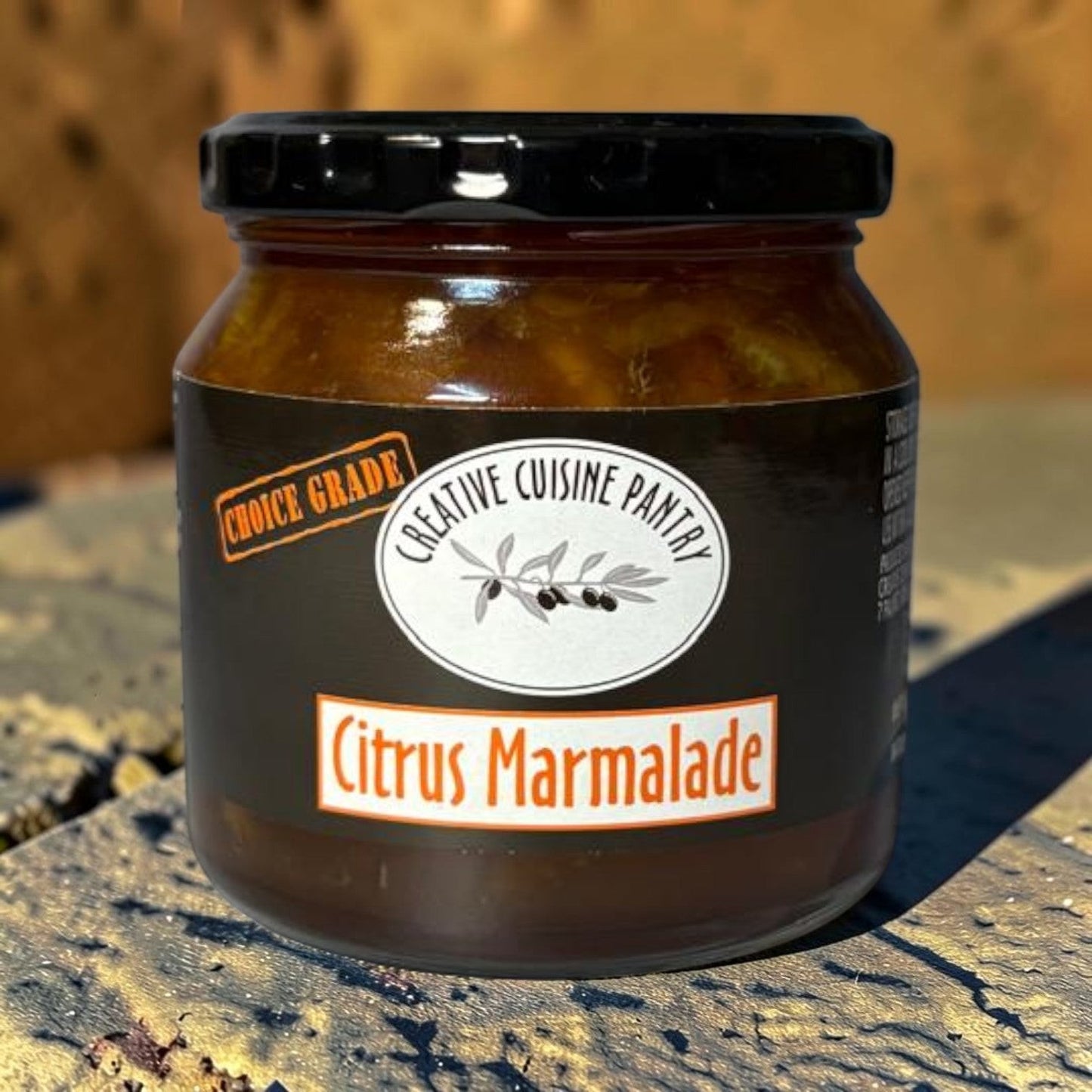 Die Spens Clarens Citrus Marmalade in a glass jar with a black lid, featuring a dark label with orange and white text.