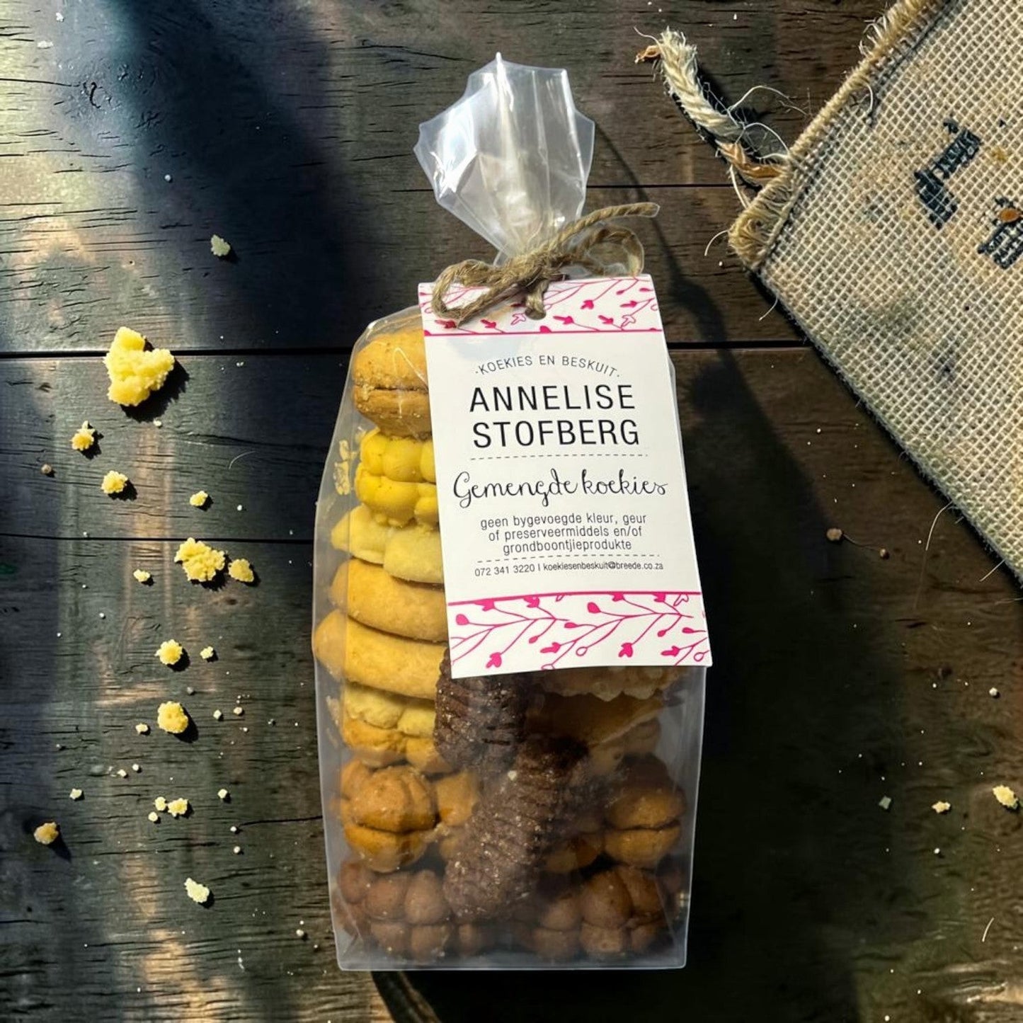 Die Spens Clarens Annelise Stofberg mixed cookies in a clear bag, featuring golden and chocolate varieties. Homemade, traditional biscuits.