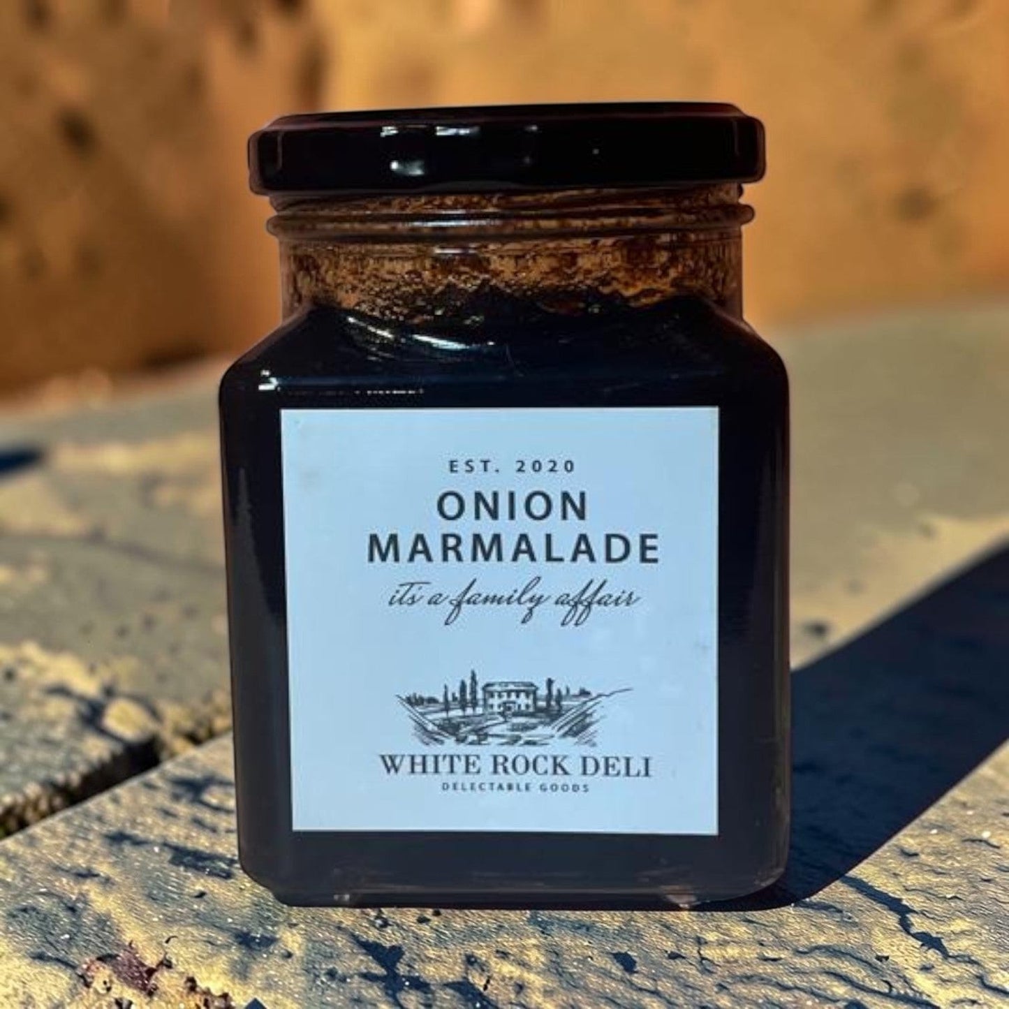 Die Spens Clarens White Rock Deli Onion Marmalade in a glass jar with a black lid. Dark, rich condiment perfect for cheeseboards.