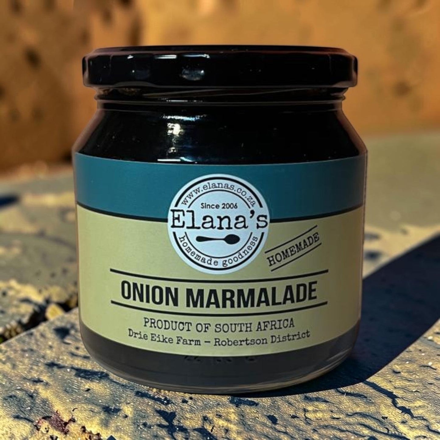 Die Spens Clarens Elana's Onion Marmalade, a sweet and savory condiment made in South Africa. Glass jar with a black lid and a light green label.