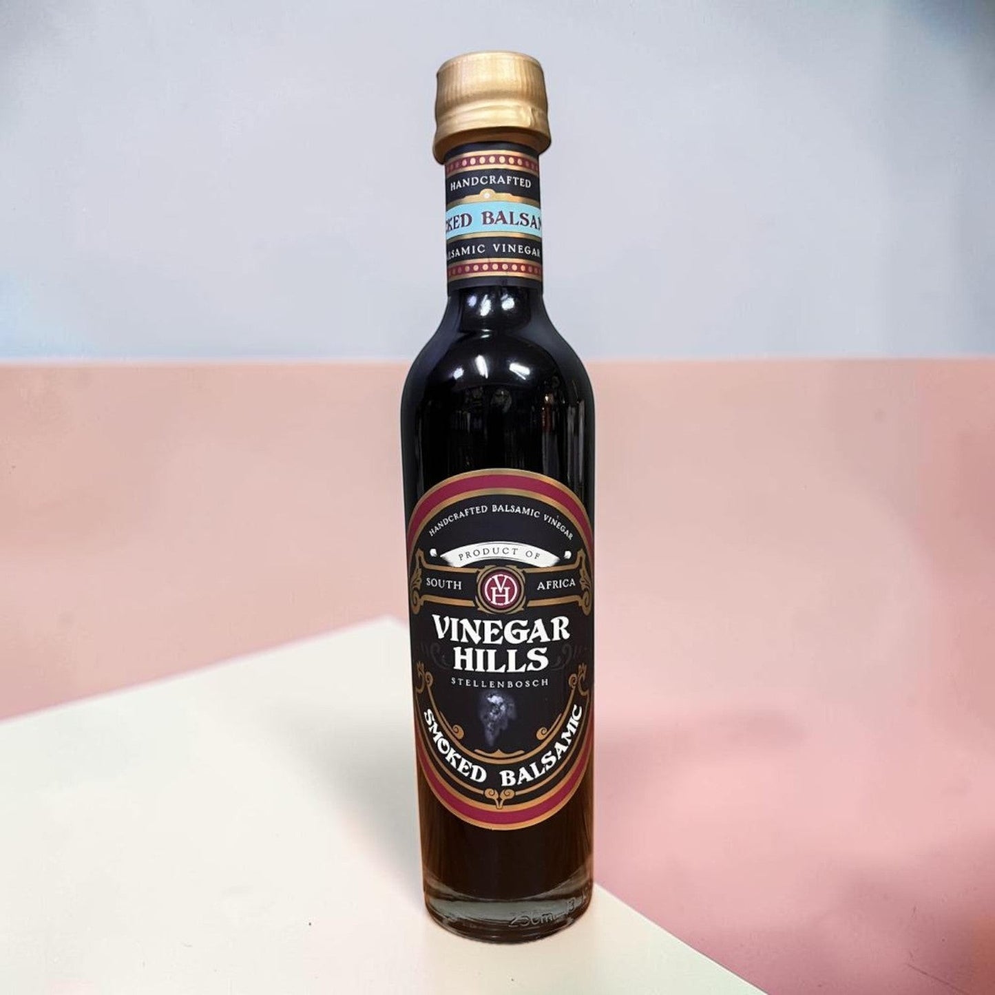 Die Spens Clarens Smoked Balsamic Vinegar bottle from Vinegar Hills, Stellenbosch, South Africa. Dark glass bottle with a gold cap and a black label detailing the product.