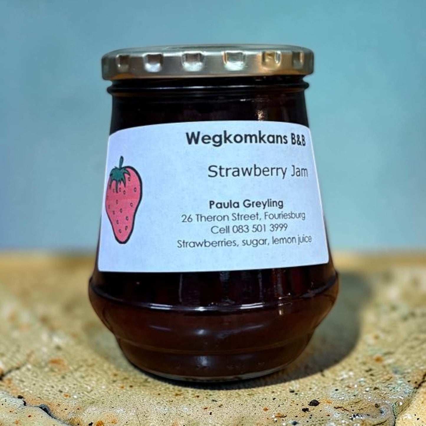 Die Spens Clarens homemade strawberry jam in a glass jar with a white label featuring a strawberry illustration and product details.
