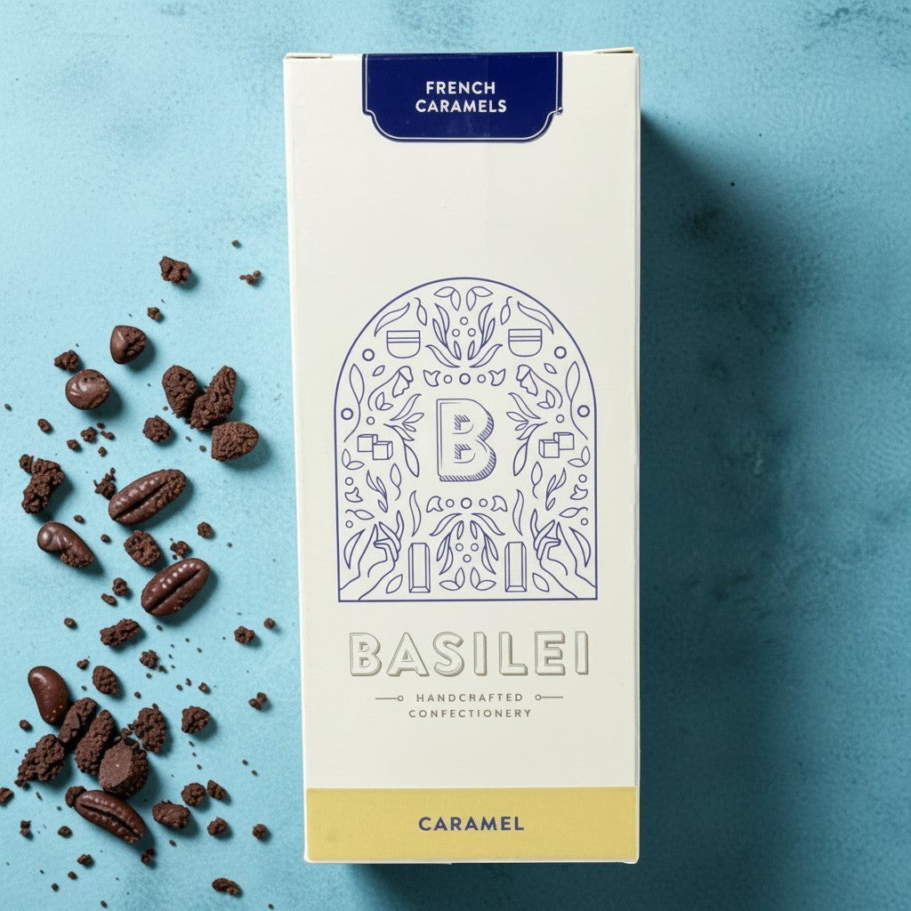 Die Spens Clarens Basilei French Caramels box with scattered chocolate pieces and coffee beans on a blue background.