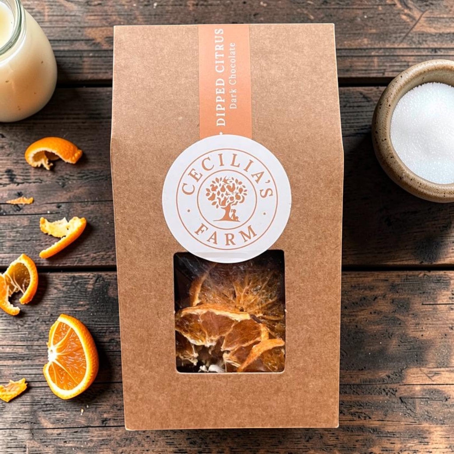 Die Spens Clarens Chocolate Dipped Citrus slices, candied and coated in dark chocolate, presented in a brown paper box with a window.