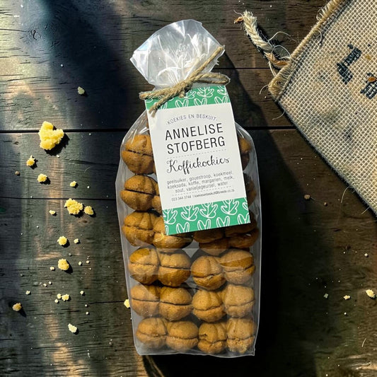 Die Spens Clarens Annelise Stofberg Koffiekoekies, coffee-infused biscuits in a clear bag tied with twine. Traditional cookies perfect with hot beverages.