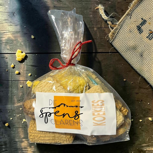 Die Spens Clarens bag of mixed koekies (cookies) with various textures and golden-brown colours, tied with red string.