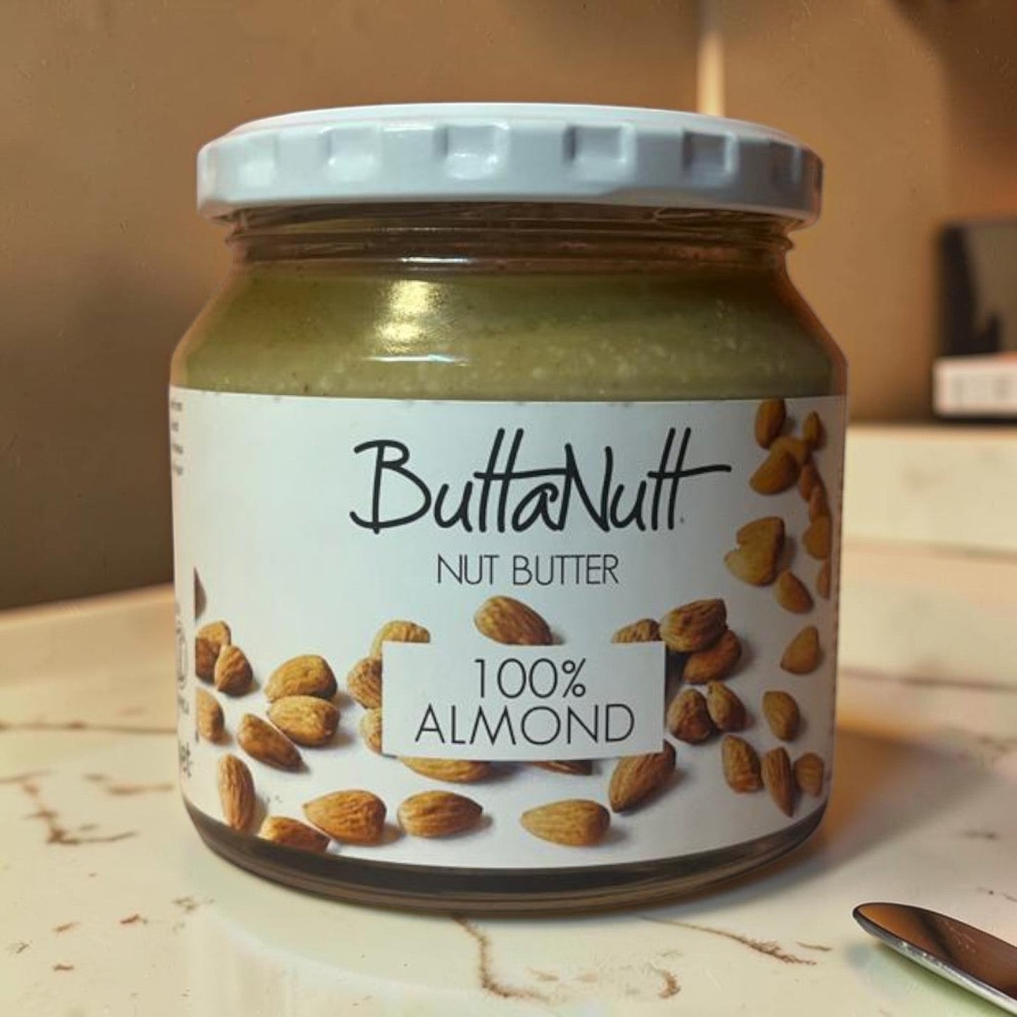 Die Spens Clarens Buttanutt 100% Almond Nut Butter in a glass jar with a white lid. Smooth, creamy almond butter.