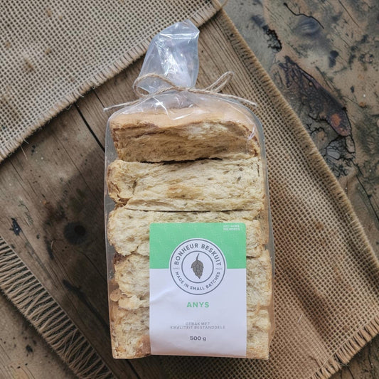 Die Spens Clarens Aniseed Hops biscuits in a clear plastic bag, tied with twine, showing their golden-brown color and textured surface.