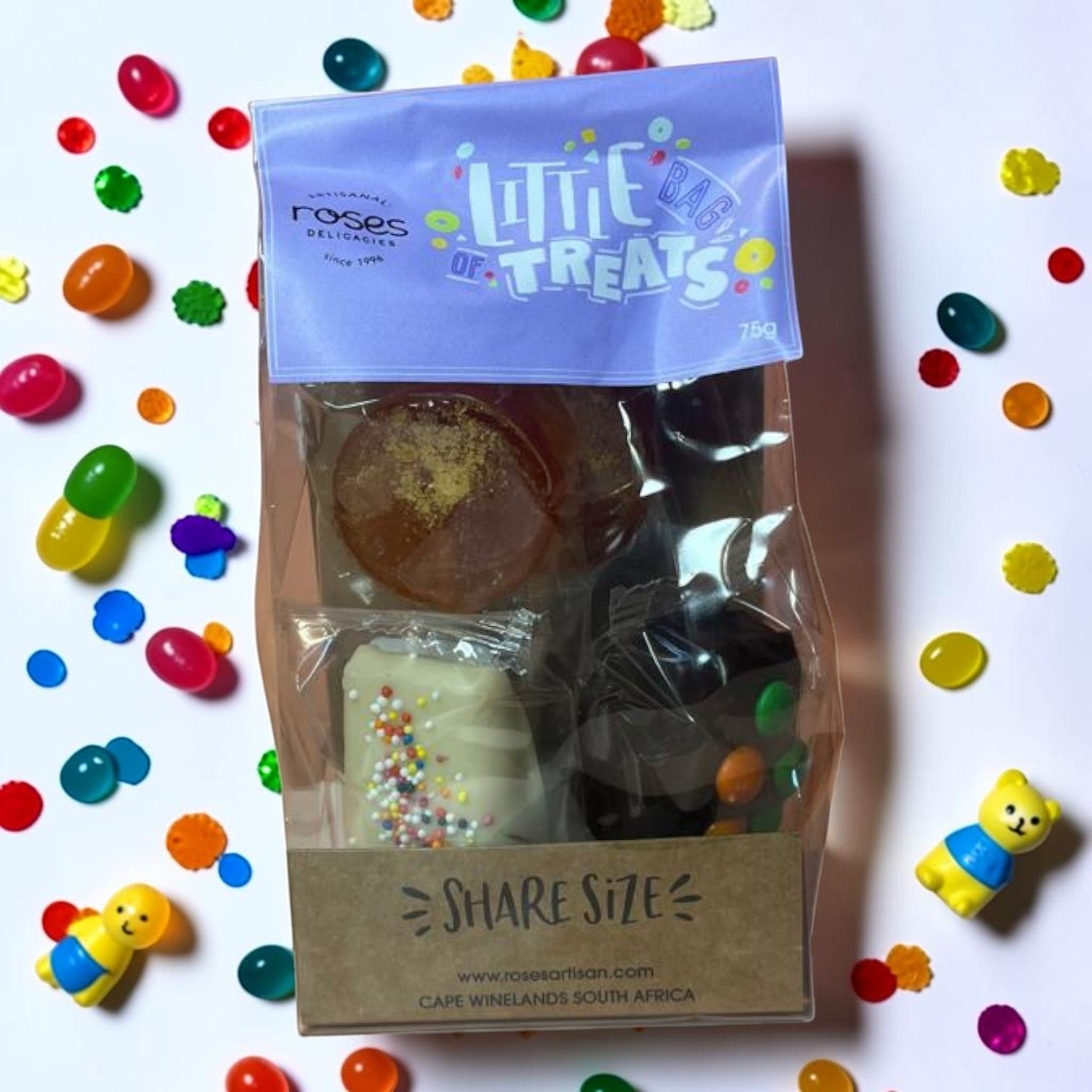 Die Spens Clarens Little Bag of Treats assortment of artisanal sweets, including a white chocolate bar with sprinkles and round amber candies.