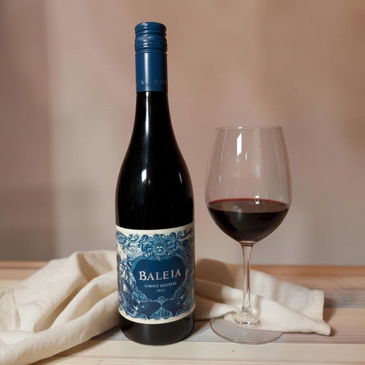 Die Spens Clarens Baleia Vinho Rochas red wine bottle and glass, featuring a blue and white label with whale imagery.