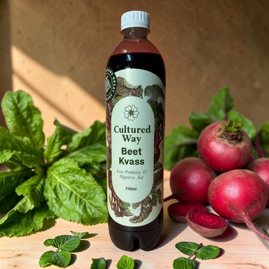 Die Spens Clarens Cultured Way Beet Kvass live probiotic and digestive aid in a 750ml bottle, surrounded by fresh beets and greens.