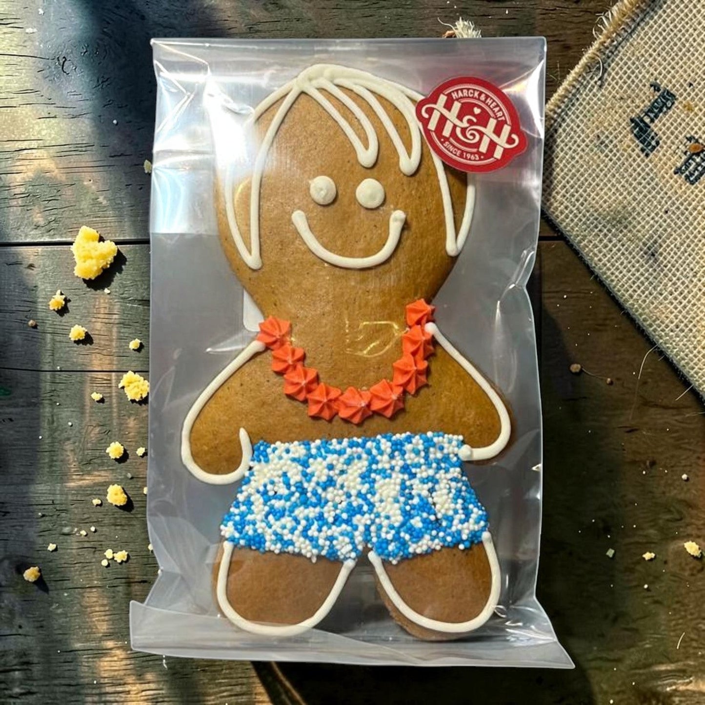 Die Spens Clarens Ben and Betty gingerbread cookie with white icing hair, orange lei, and blue & white sprinkle shorts.