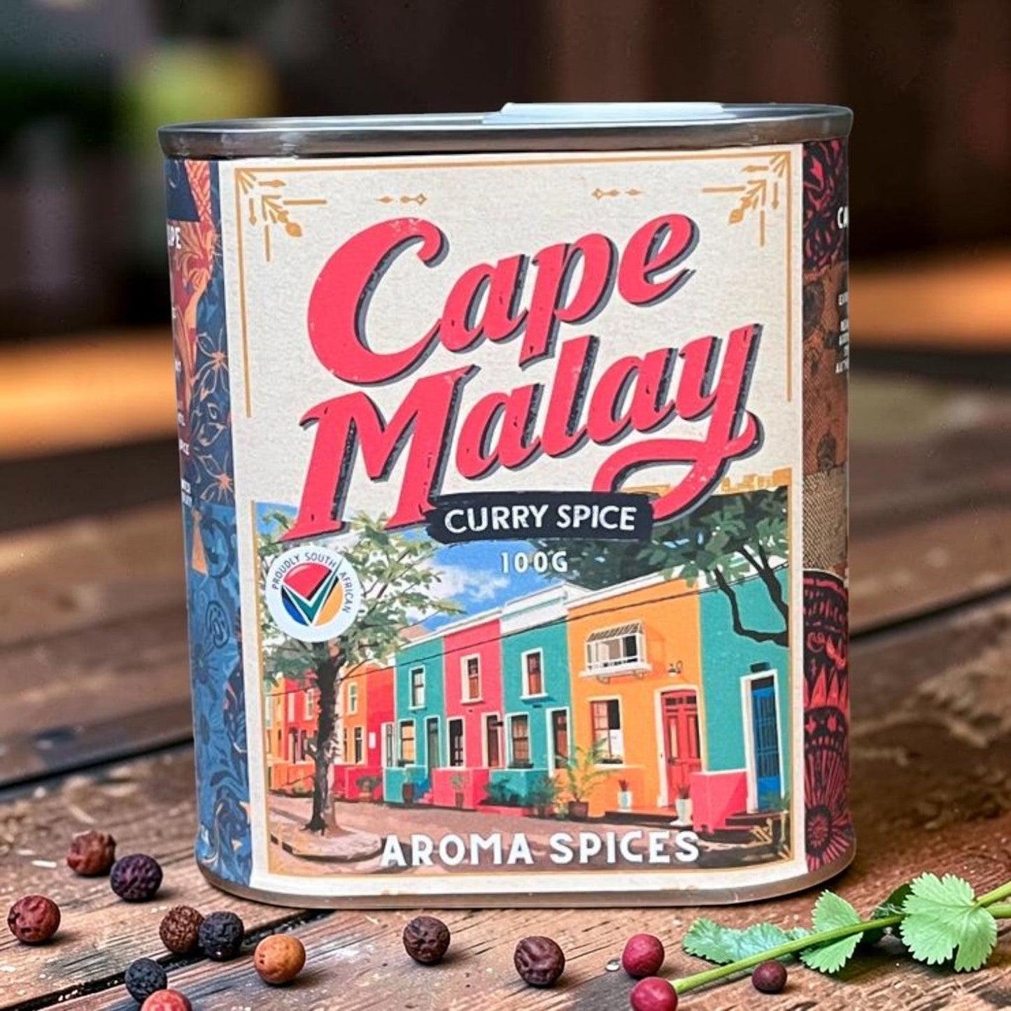 Die Spens Clarens Cape Malay Curry Spice blend in a decorative tin featuring colourful houses and a tree. 100g.