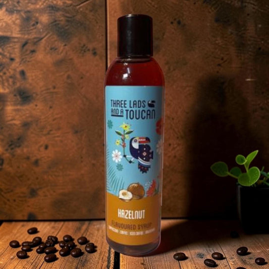 Die Spens Clarens Three Lads and a Toucan Hazelnut Flavoured Syrup bottle with toucan and hazelnut illustration.