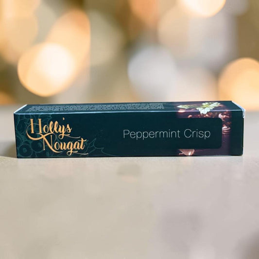 Die Spens Clarens Holly's Nougat Peppermint Crisp box, dark green with gold lettering and festive bokeh background.