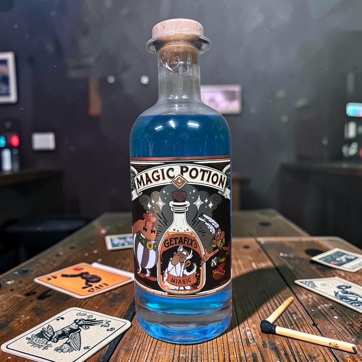 Die Spens Clarens Geta Fixs Magic Potion, a blue liquid in a clear glass bottle with a cork stopper and a whimsical label.