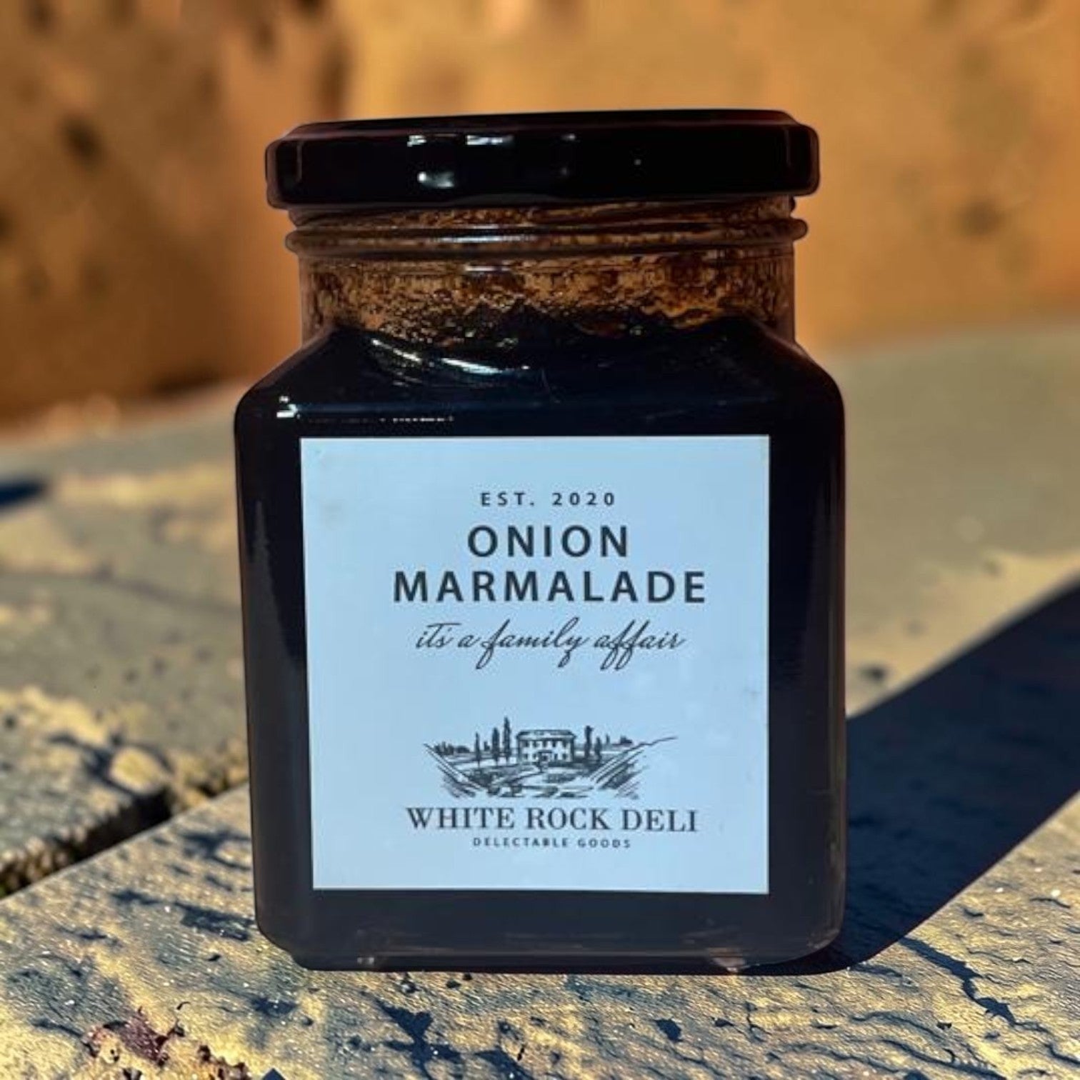 Die Spens Clarens White Rock Deli Onion Marmalade in a glass jar with a black lid. Dark, rich condiment perfect for cheeseboards.