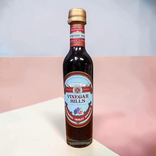 Die Spens Clarens Raspberry Merlot Balsamic Vinegar bottle, dark red liquid, gold cap, artisanal South African product.