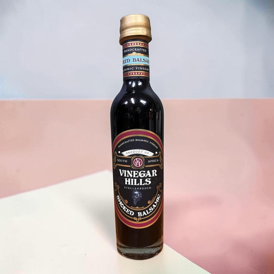 Die Spens Clarens Smoked Balsamic Vinegar bottle from Vinegar Hills, Stellenbosch, South Africa. Dark glass bottle with a gold cap and a black label detailing the product.
