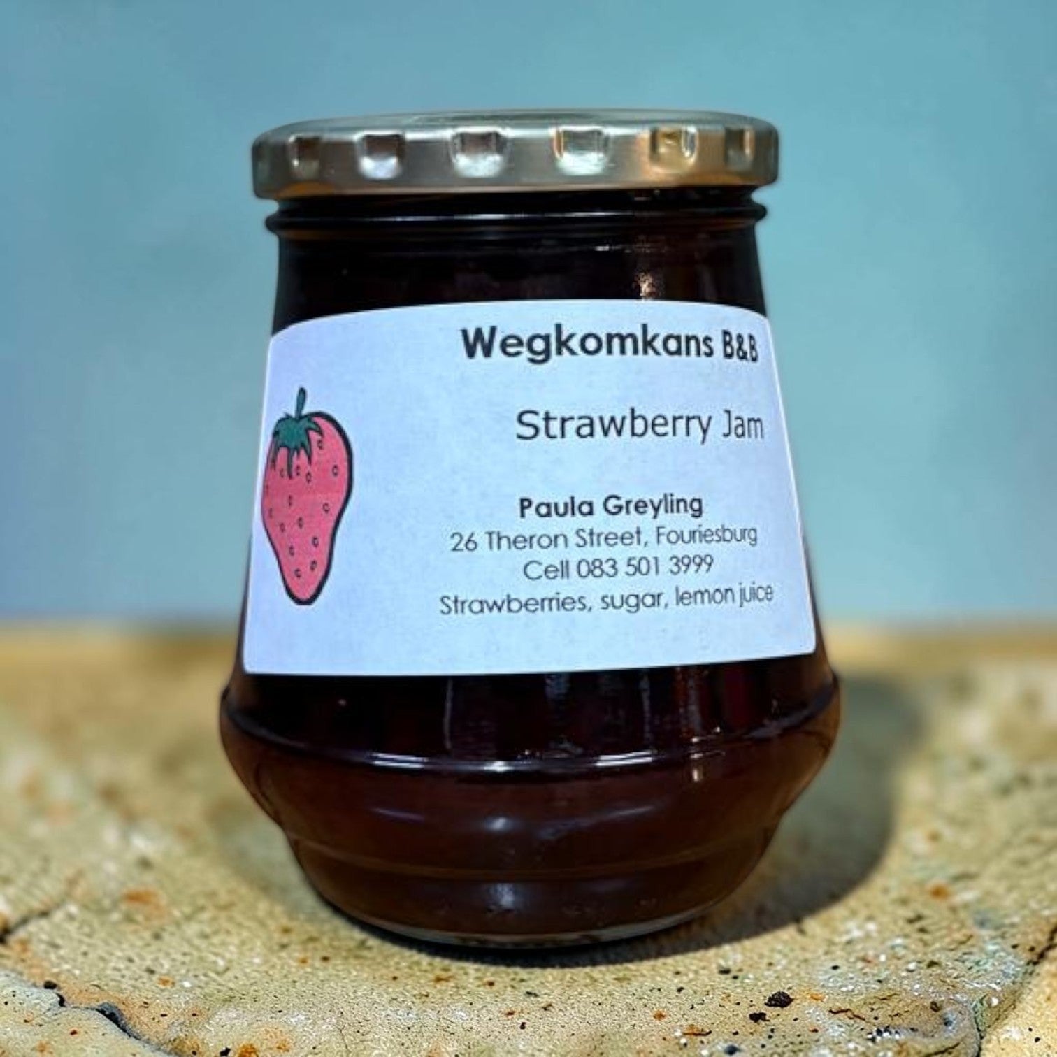 Die Spens Clarens homemade strawberry jam in a glass jar with a white label featuring a strawberry illustration and product details.