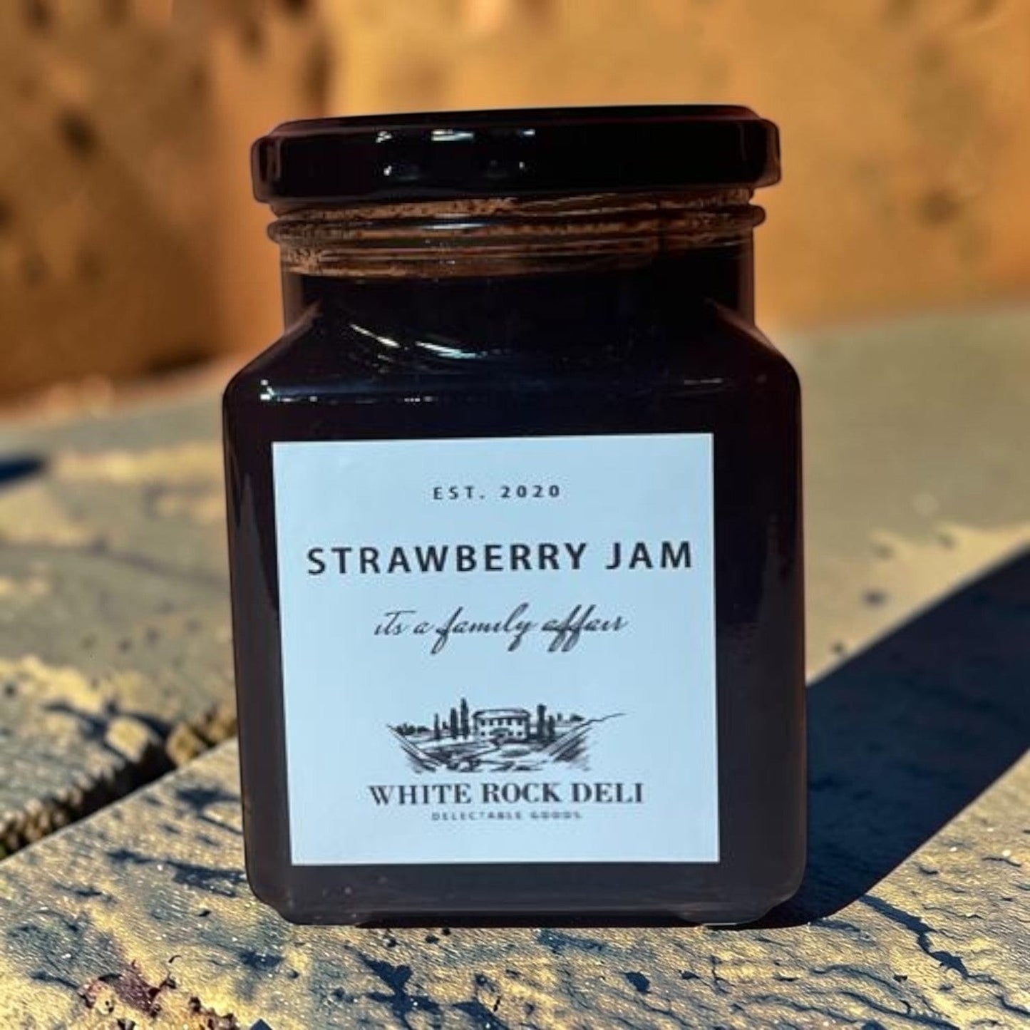 Die Spens Clarens White Rock Deli Strawberry Jam in a glass jar with a black lid. Classic fruit spread.