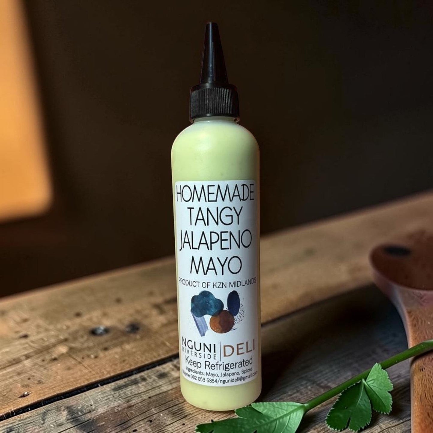 Die Spens Clarens Tangy Jalapeno Mayo in a squeeze bottle with a black cap. Creamy green condiment with a spicy kick.