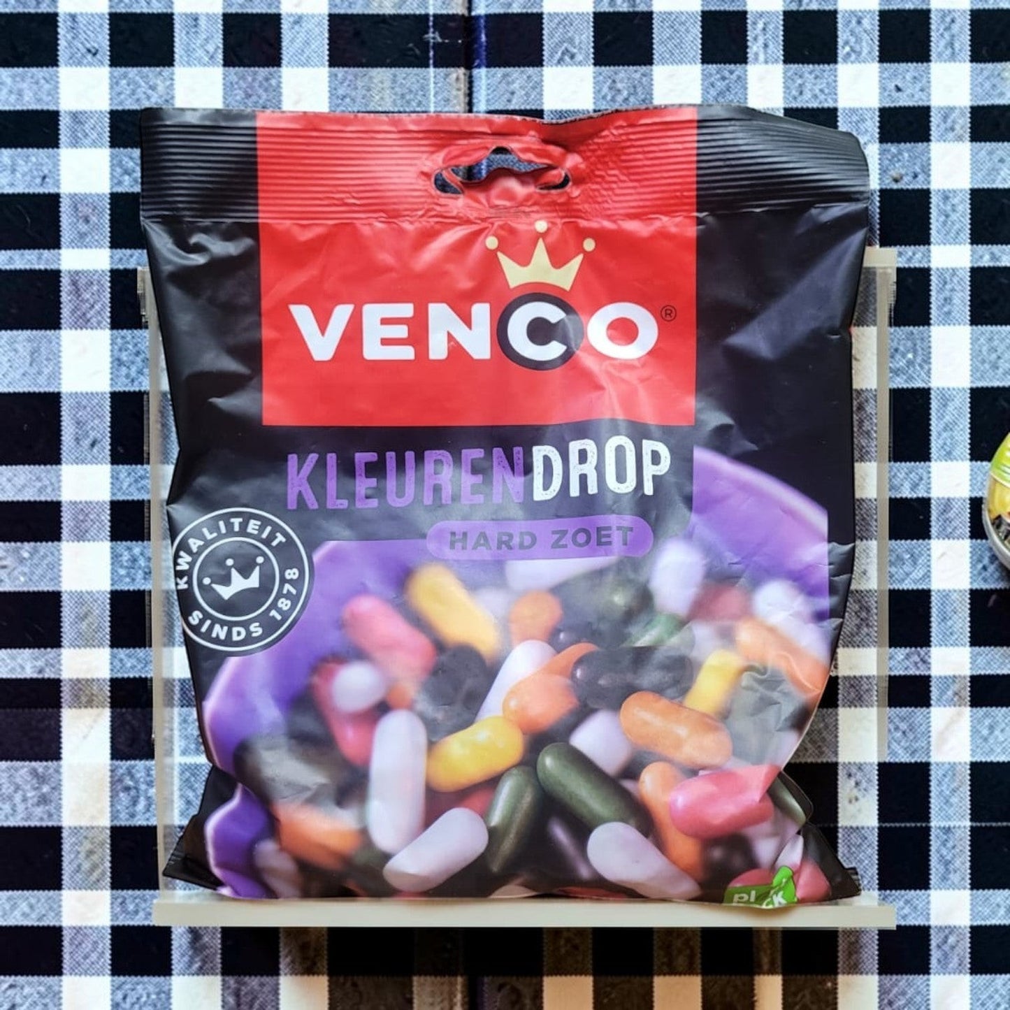 Die Spens Clarens Venco Kleuren Drop hard sweet licorice candy assortment in a black bag with colorful pieces.