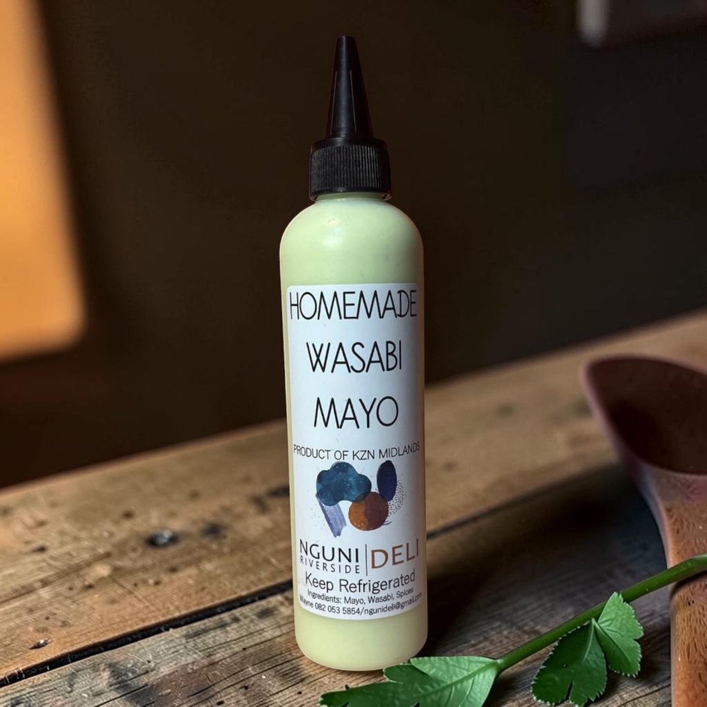 Die Spens Clarens Nguni Deli homemade wasabi mayo in a squeeze bottle with a black cap. Creamy green condiment with a zesty wasabi flavour.