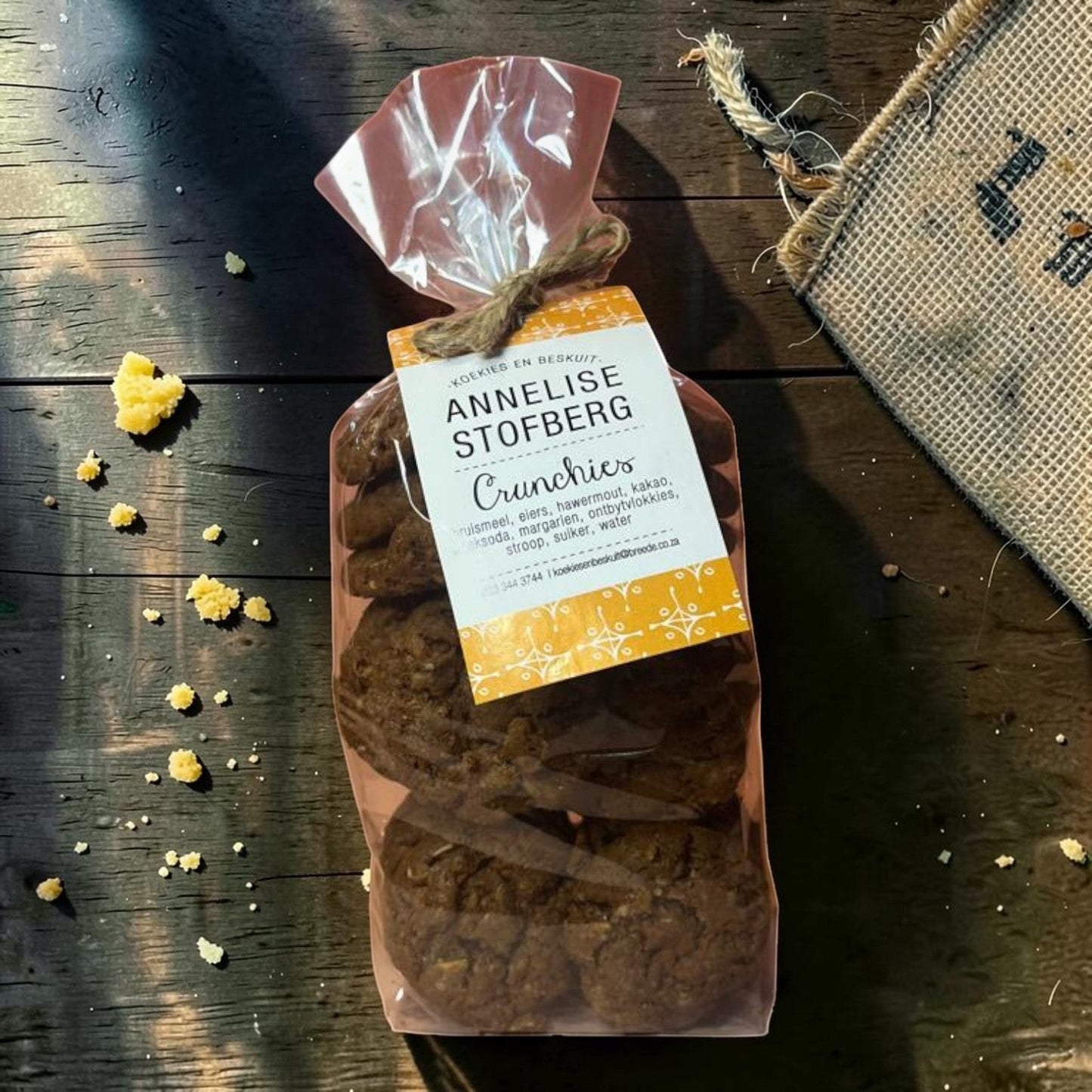 Die Spens Clarens Annelise Stofberg Crunchies cookies in a clear bag with a yellow tag. Made with flour, eggs, oats, and cocoa.