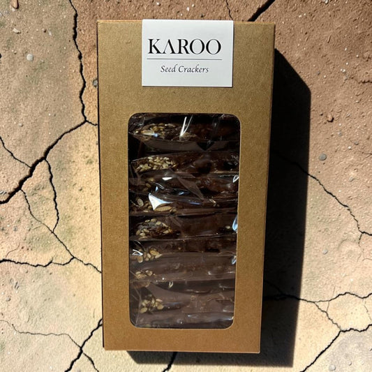 Die Spens Clarens Karoo Dark Chocolate Seed Crackers, a box of individually wrapped seed crackers coated in dark chocolate.
