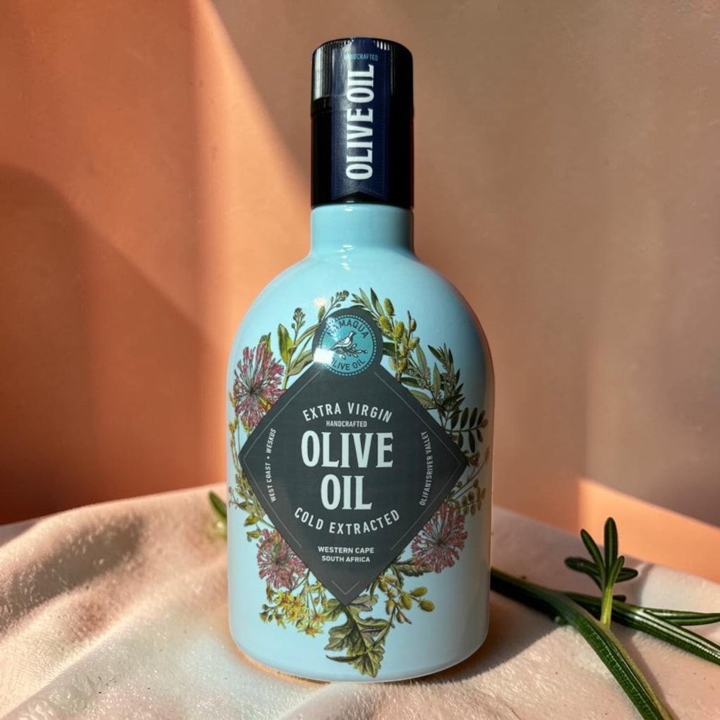 Die Spens Clarens Namaqua Extra Virgin Olive Oil in a decorative light blue glass bottle with floral design. Cold extracted from Western Cape, South Africa.