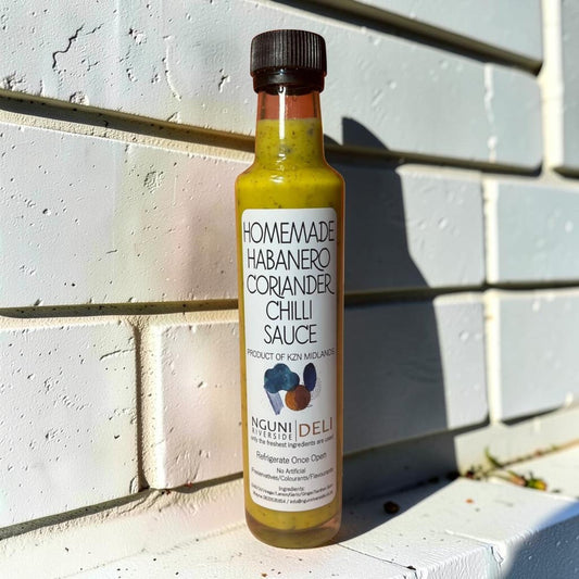 Die Spens Clarens Nguni Deli Habanero Coriander Chilli Sauce bottle with yellow-green sauce and visible herbs.
