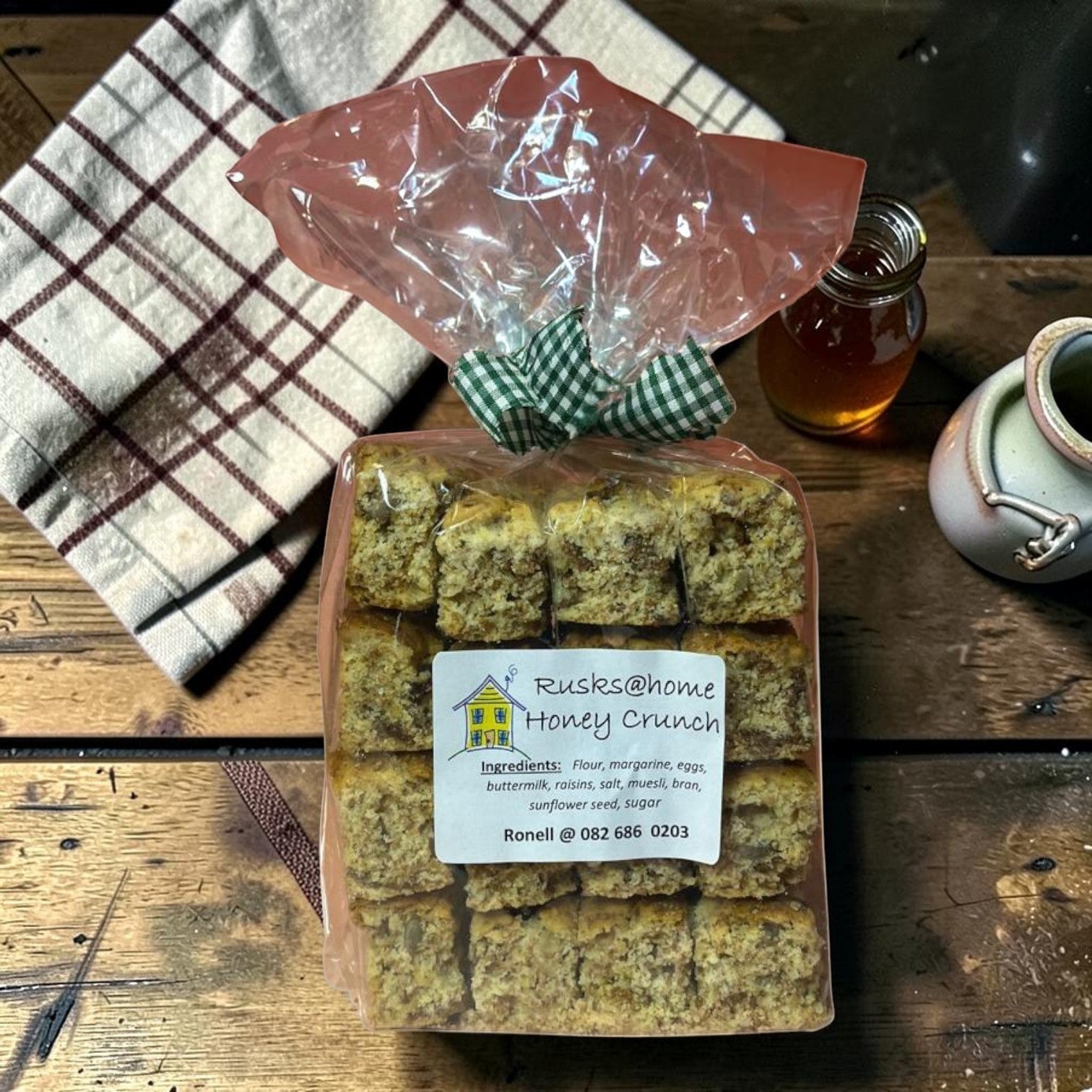 Die Spens Clarens Honey Crunch rusks in a clear bag, showing a crunchy texture with visible seeds and raisins.