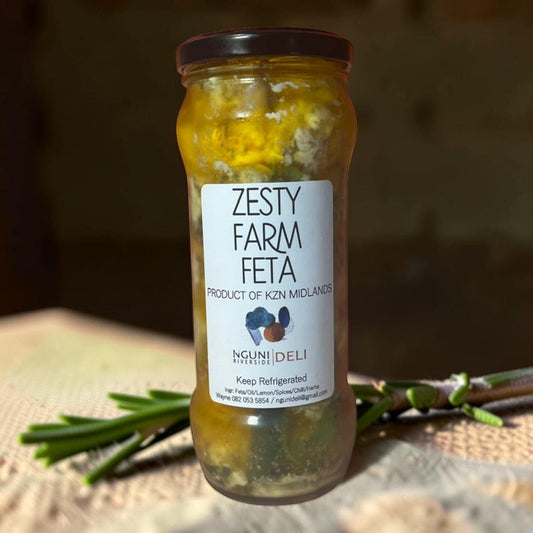 Die Spens Clarens Zesty Farm Feta marinated in oil, lemon, spices, chili, and herbs in a glass jar.