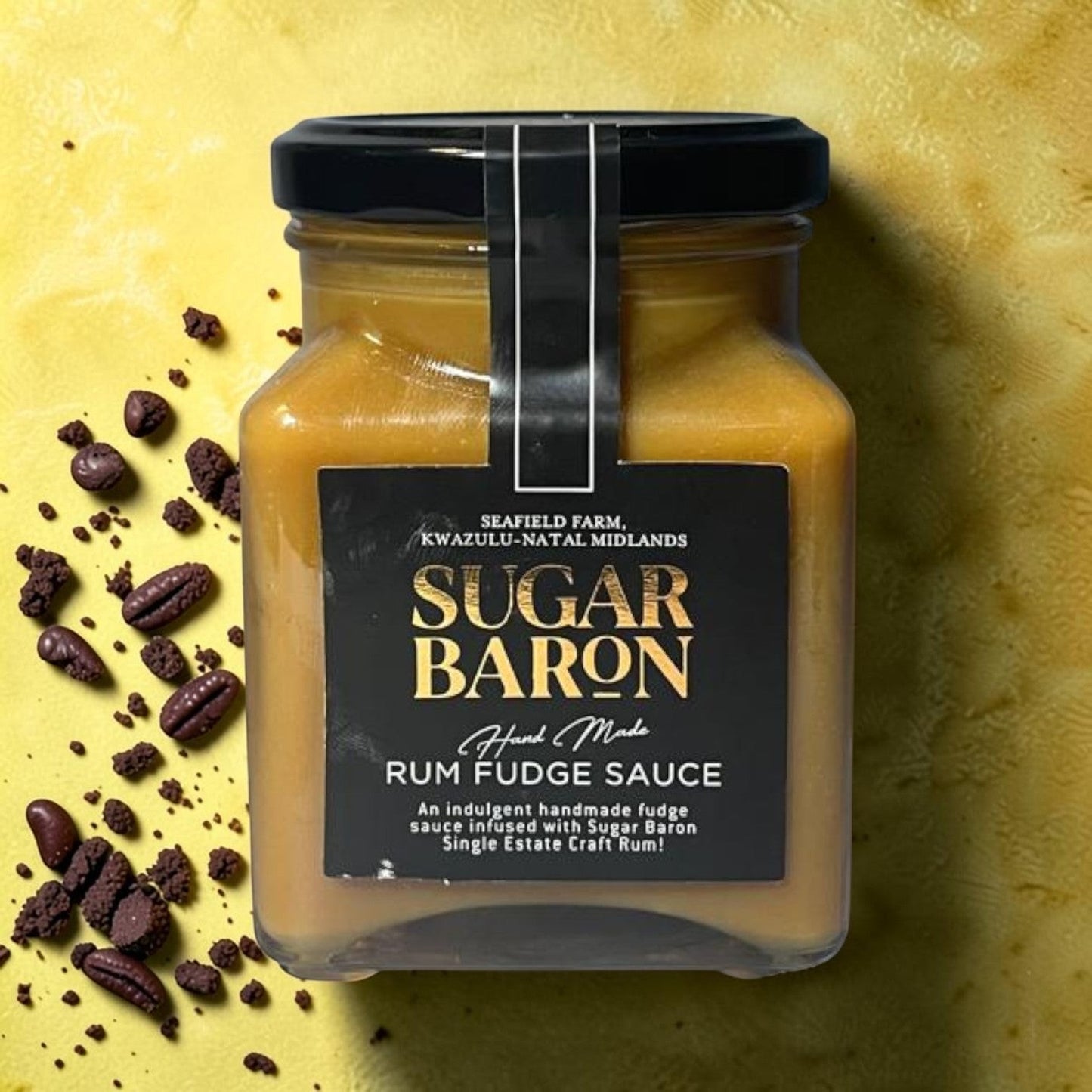 Die Spens Clarens Sugar Baron handmade rum fudge sauce in a glass jar with a black lid, drizzled over desserts.